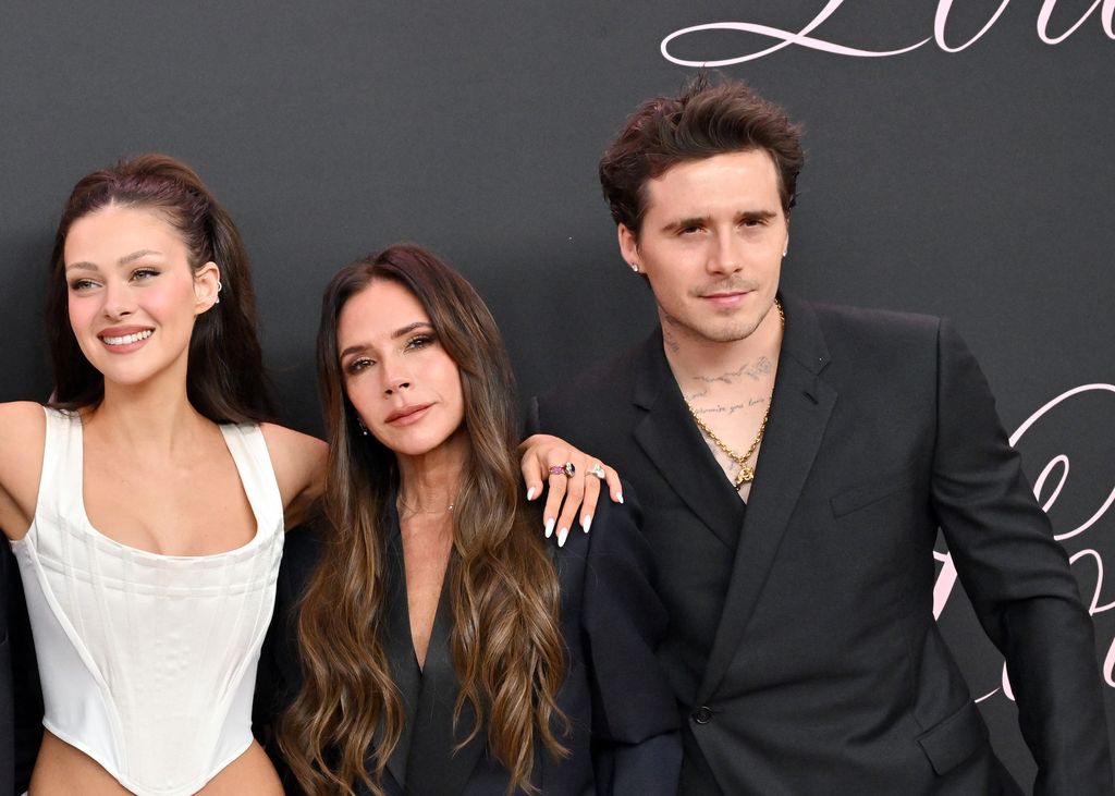 Nicola Peltz Beckham, Victoria and Brooklyn Beckham pictured dressed smartly and posing at event