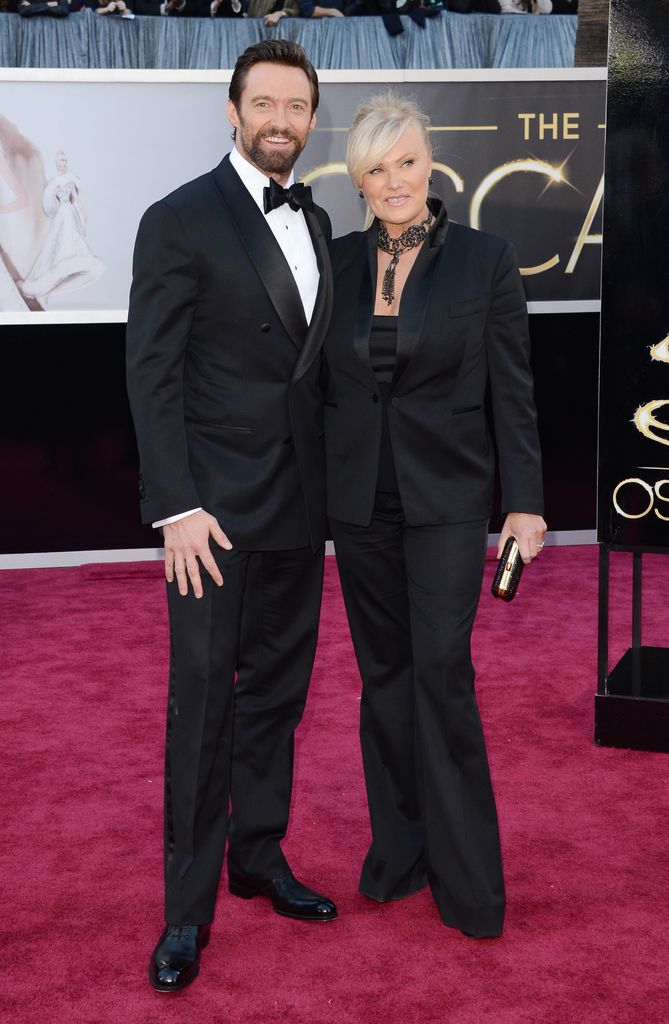 Hugh Jackman and wife Deborra-Lee Furness wearing black suits with satin lapels