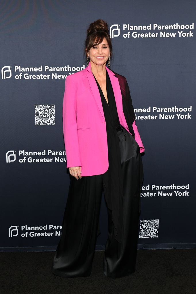 Gina Gershon attends the 2025 Planned Parenthood New York Gala in a pink and black suit
