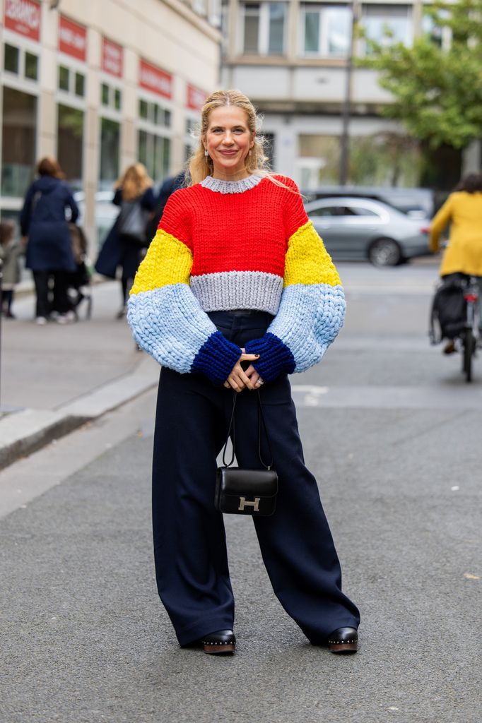 Christine Wuerfel-Stauss / Christine WÃ¼rfel-Stauss wears red yellow blue sweater Loewe, Hermes bag, navy pants, clogs Hermes during Womenswear Spring/Summer 2025 as part of  Paris Fashion Week on September 30, 2024 in Paris, France.