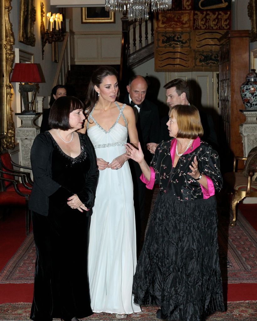 Kate in evening gown talking to people in hallway at clarence house