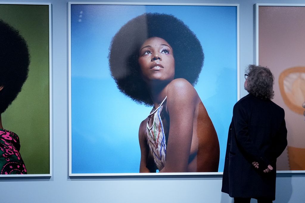 A person walks past the photos by Kwame Brathwaite  during a press preview of the exhibition Giants Art from the Dean Collection of Swizz Beatz and Alicia Keys at the Brooklyn Museum in New York on February 6, 2024.
