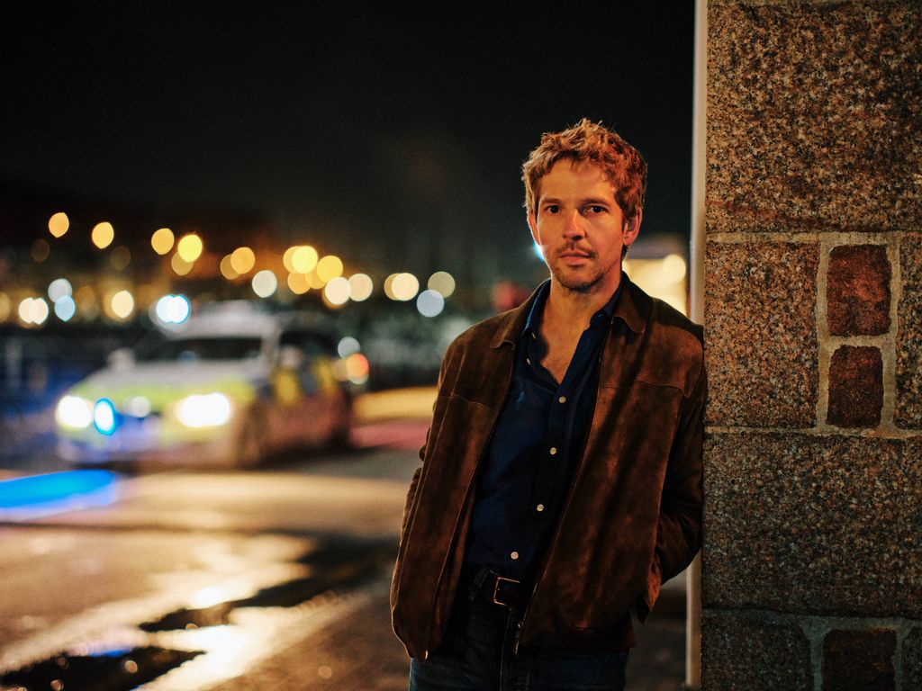 man leaning against wall at night