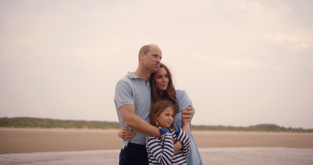 William e Kate abraçando Charlotte na praia