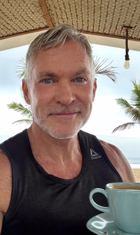 Sam Champion holding a blue coffee cup