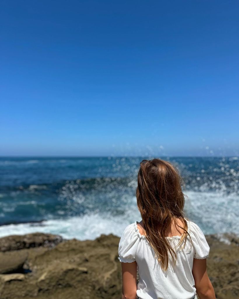 rachel bilson's daughter starring at the sea with back to camera