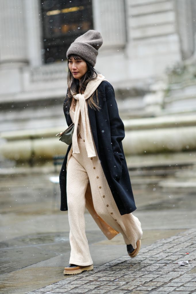 A guest at New York Fashion Week This soft, beige set is perfect for a cozy day in the snow. With wide-legged pants, a long cardigan, and a beanie, it’s a look that keeps warmth and comfort front and center while still being effortlessly stylish.