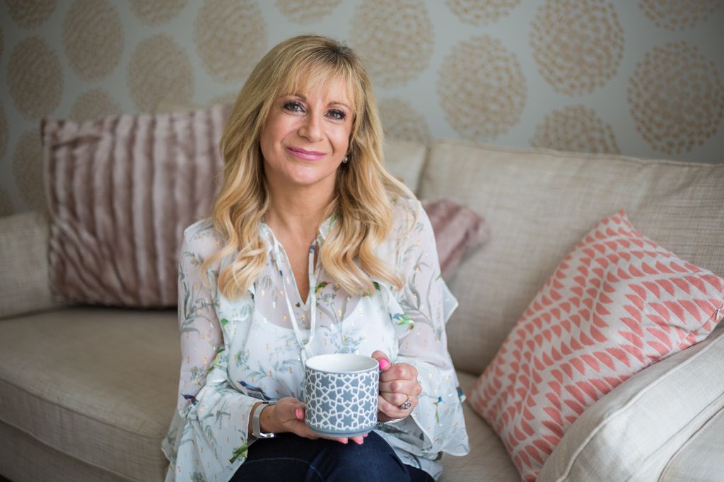 woman wearing a floral top sitting on a sofa