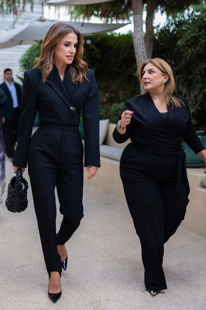 Queen Rania talking to woman in black suit