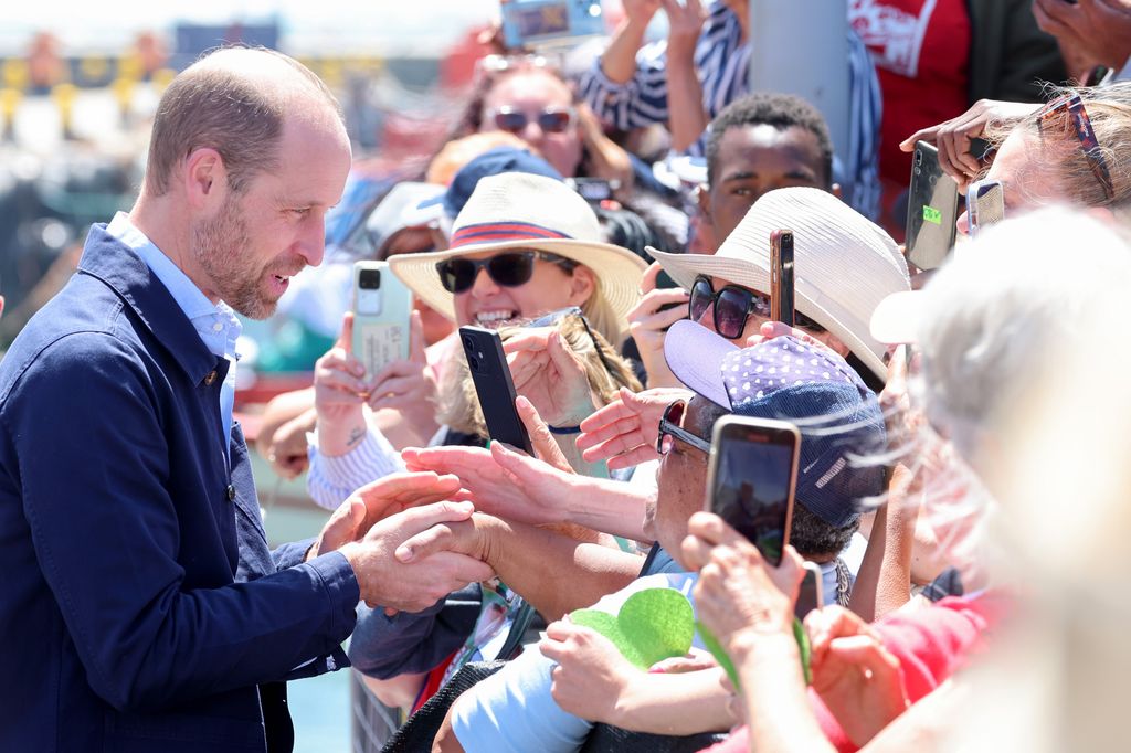 Prince William greeted by well-wishers during a visit to Kalk Bay Harbour