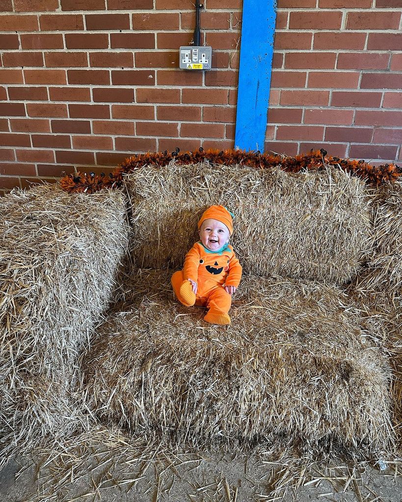 baby dressed in pumpkin outfit 