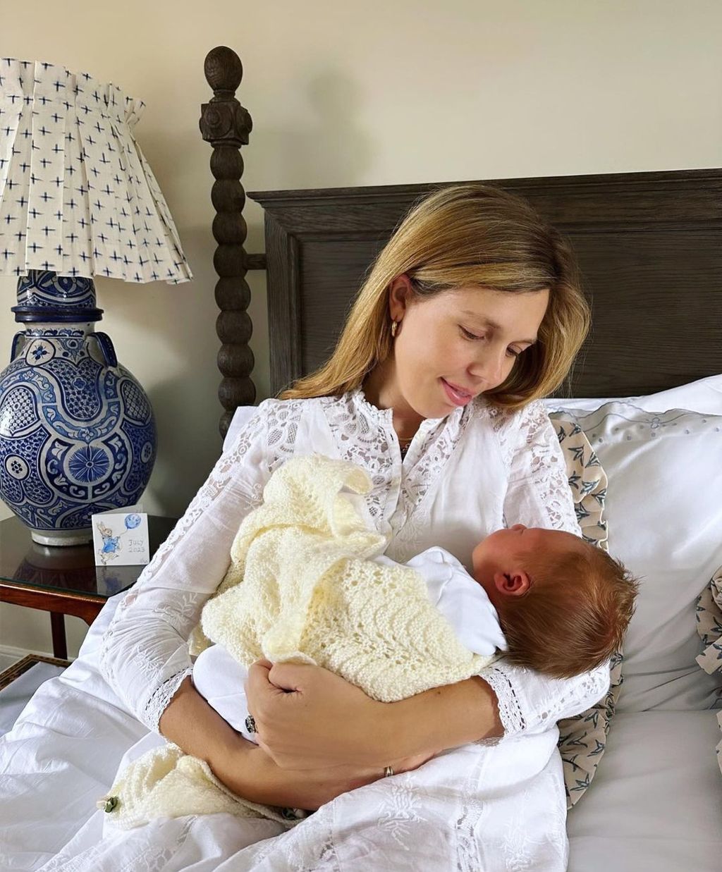 Carrie Johnson in bed cradling a baby