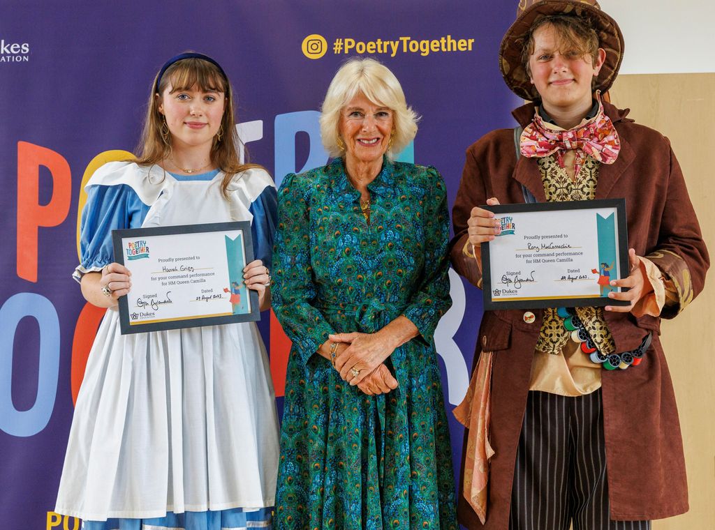 Queen Camilla on stage with Queen Camilla and The Mad Hatter 