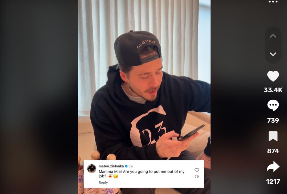 Brooklyn Beckham reading from a phone