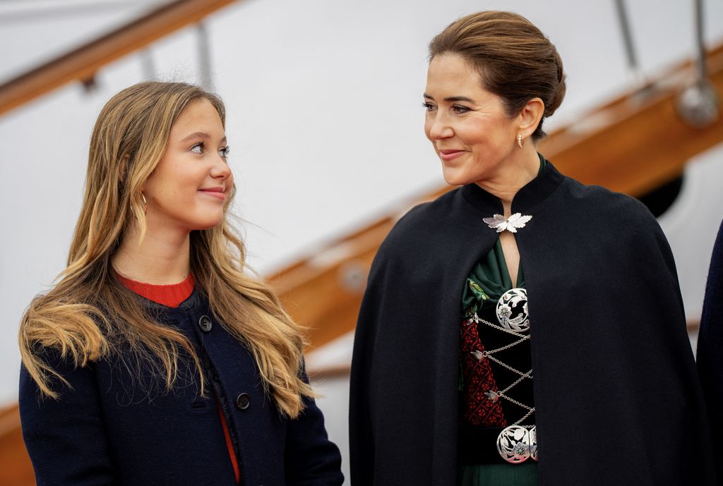 Denmark's Queen Mary and her daughter Princess Josephine (L) smile at each other upon their arrival with the Royal Yacht in Torshavn