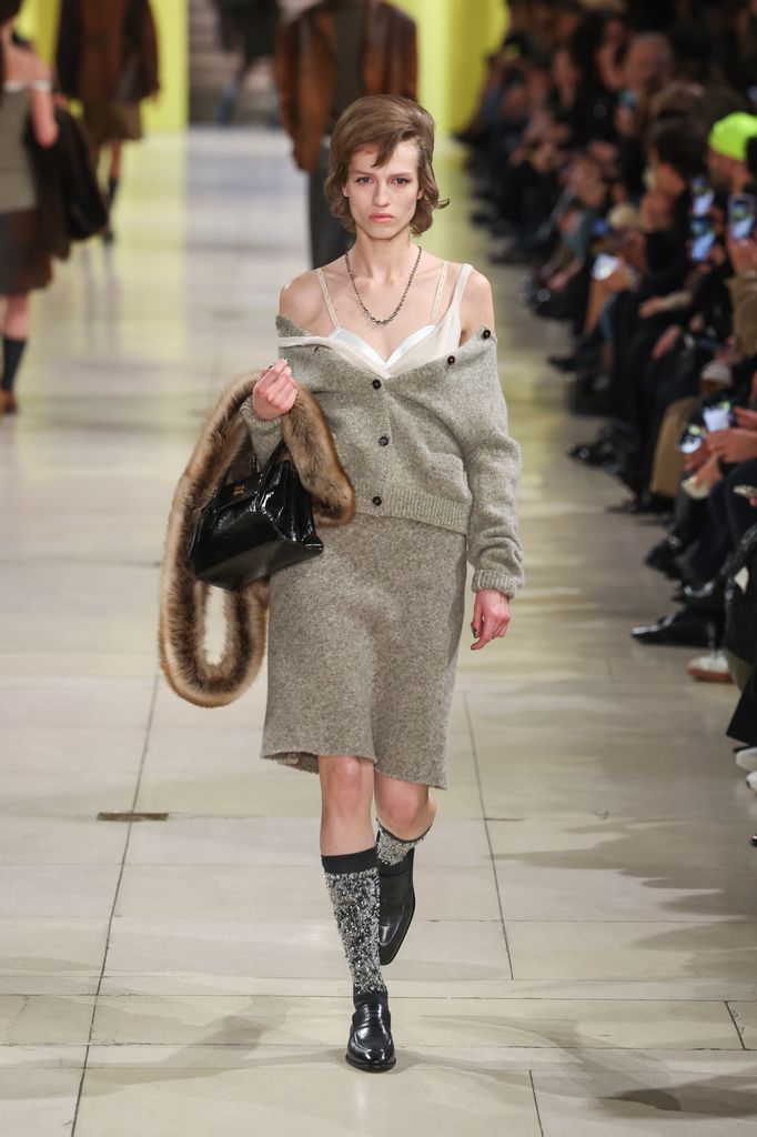 Miu Miu automne / hiver 2025 Modèle portant un ensemble et soutien-gorge en tricot
