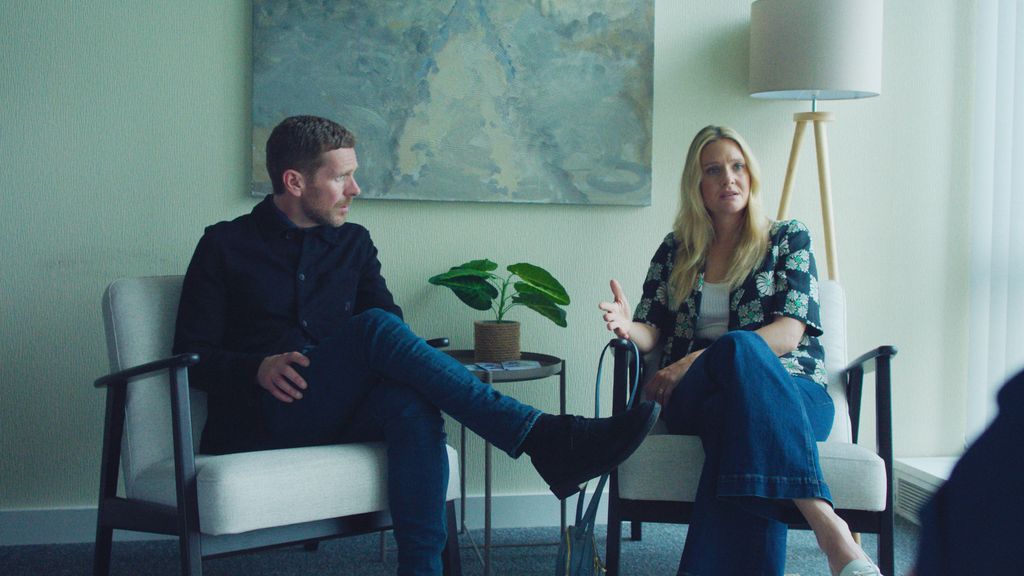 man and woman sitting in chairs next to each other in office