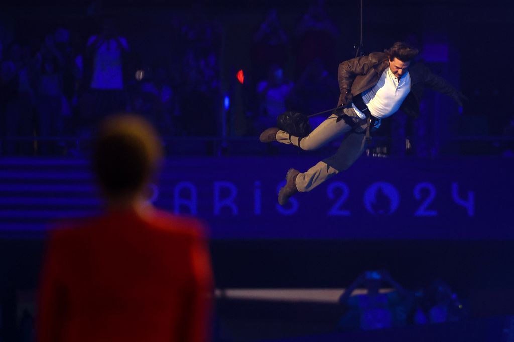 US' actor Tom Cruise lands from the roof in front one of the stadium entrances 