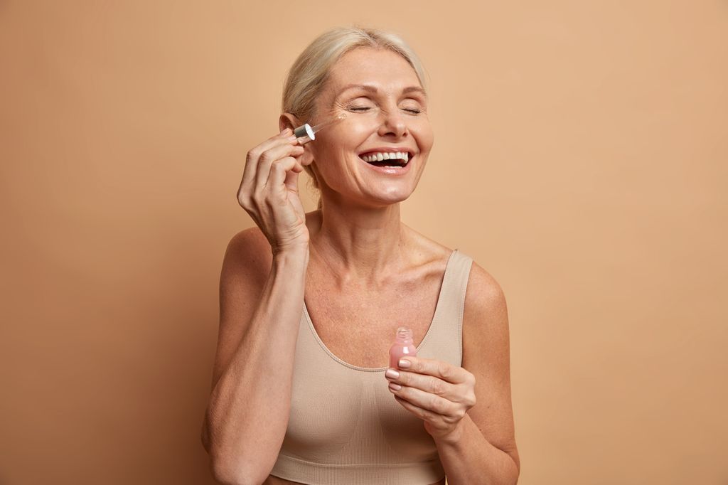 Older lady applying face serum