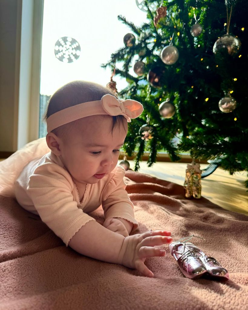 baby girl playing with tree decoration 