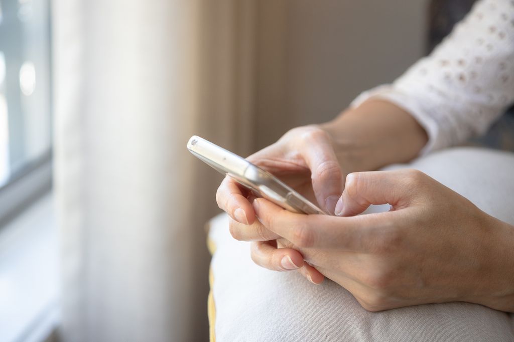 hands holding mobile phone.j