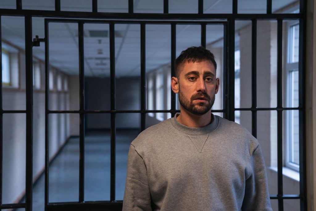 Michael Socha in character in a jail cell