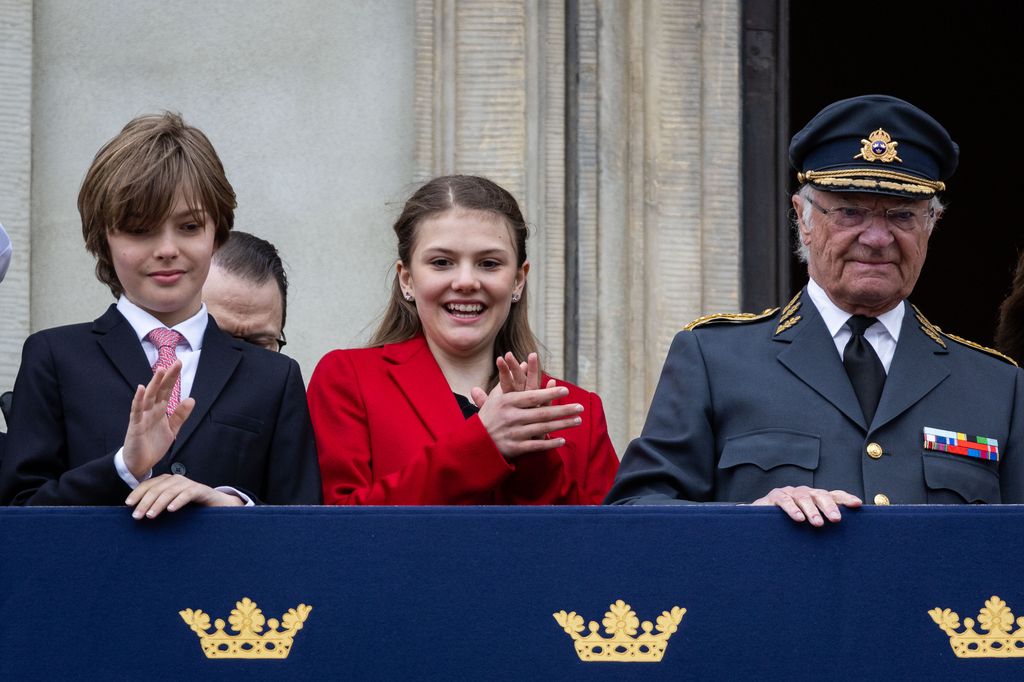 brother and sister with grandfather on balcony