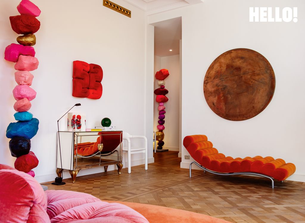 A colourful living space with contemporary art, orange and pink couches  in the three-storey apartment in Antwerp’s Graanmarkt Square
