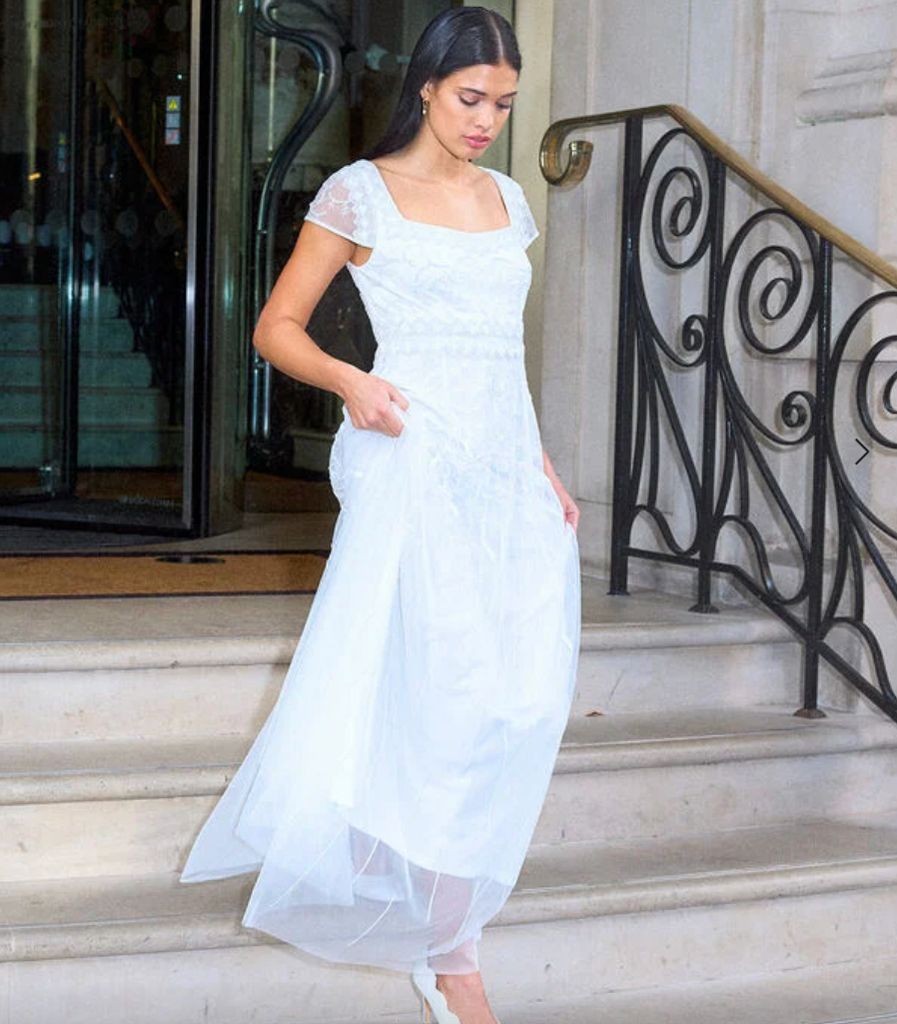 Model wearing a Monsoon wedding dress going down the stairs