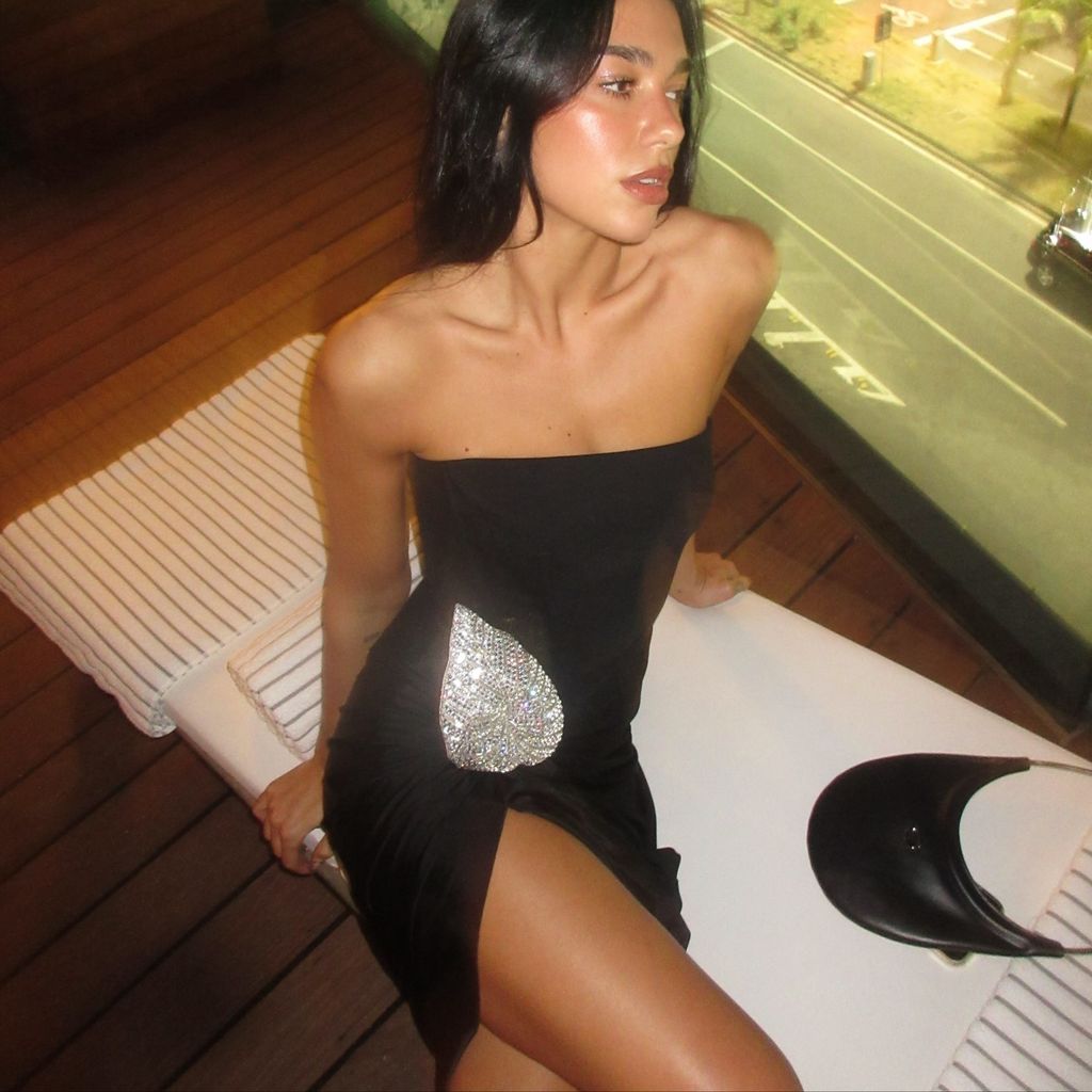 Dua Lipa poses in a strapless black mini dress on her Instagram
