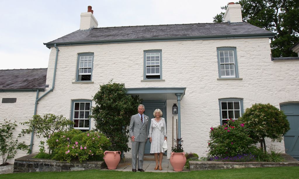 King Charles and Queen Camilla stood outside a house