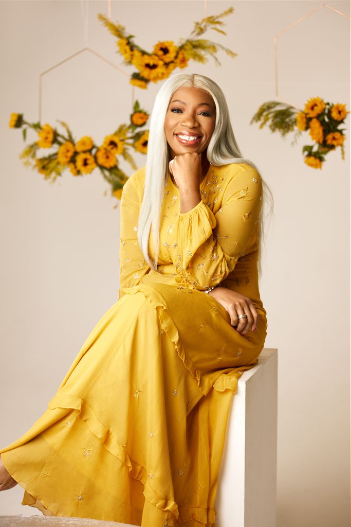 Tessy Ojo looks gorgeous in sunshine yellow dress, sunflowers hanging from the ceiling