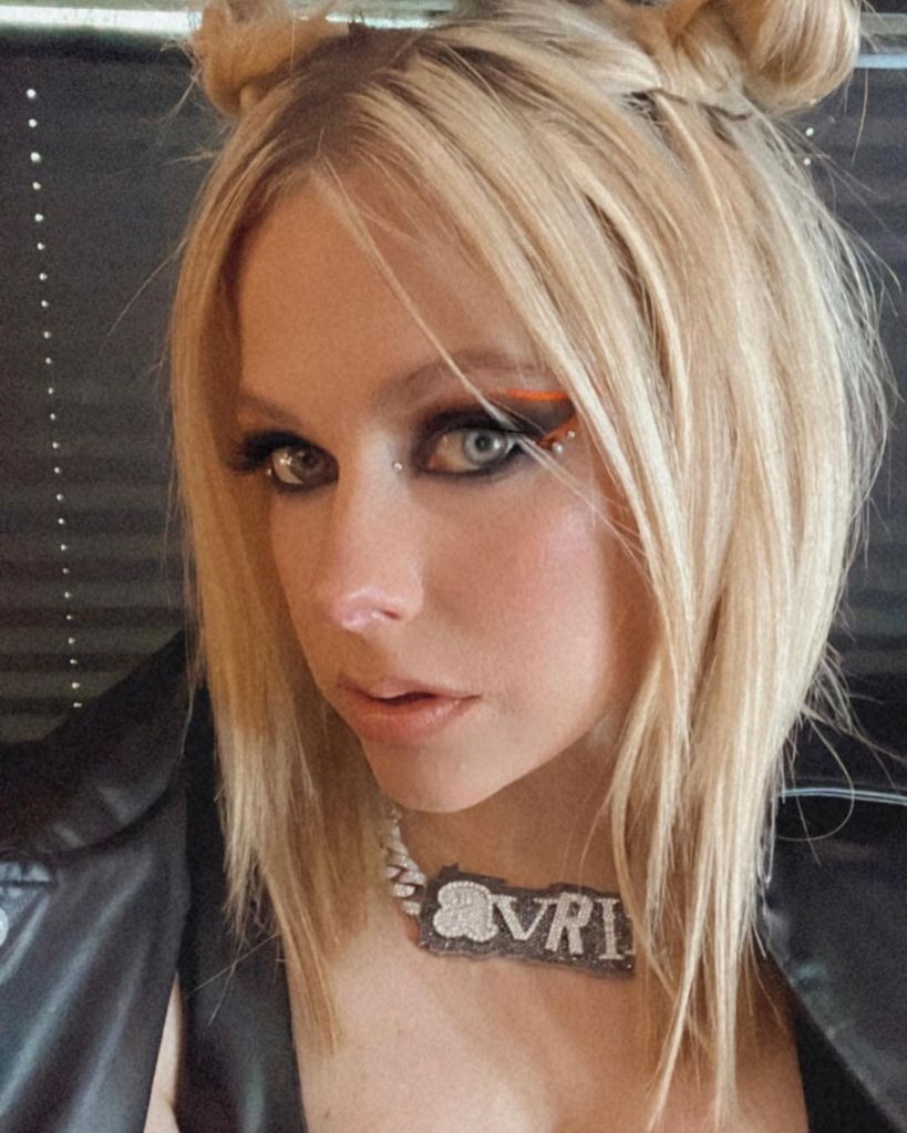 Avril Lavigne in a beaded name necklace with orange eye makeup