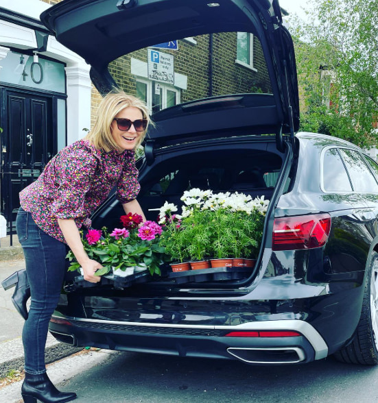 emilia putting plants in boot of car