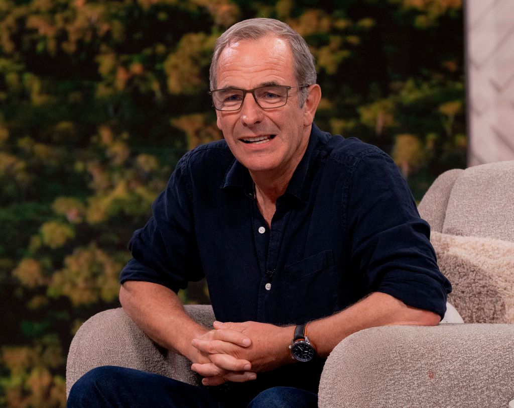 Man in blue shirt sitting on sofa in TV studio