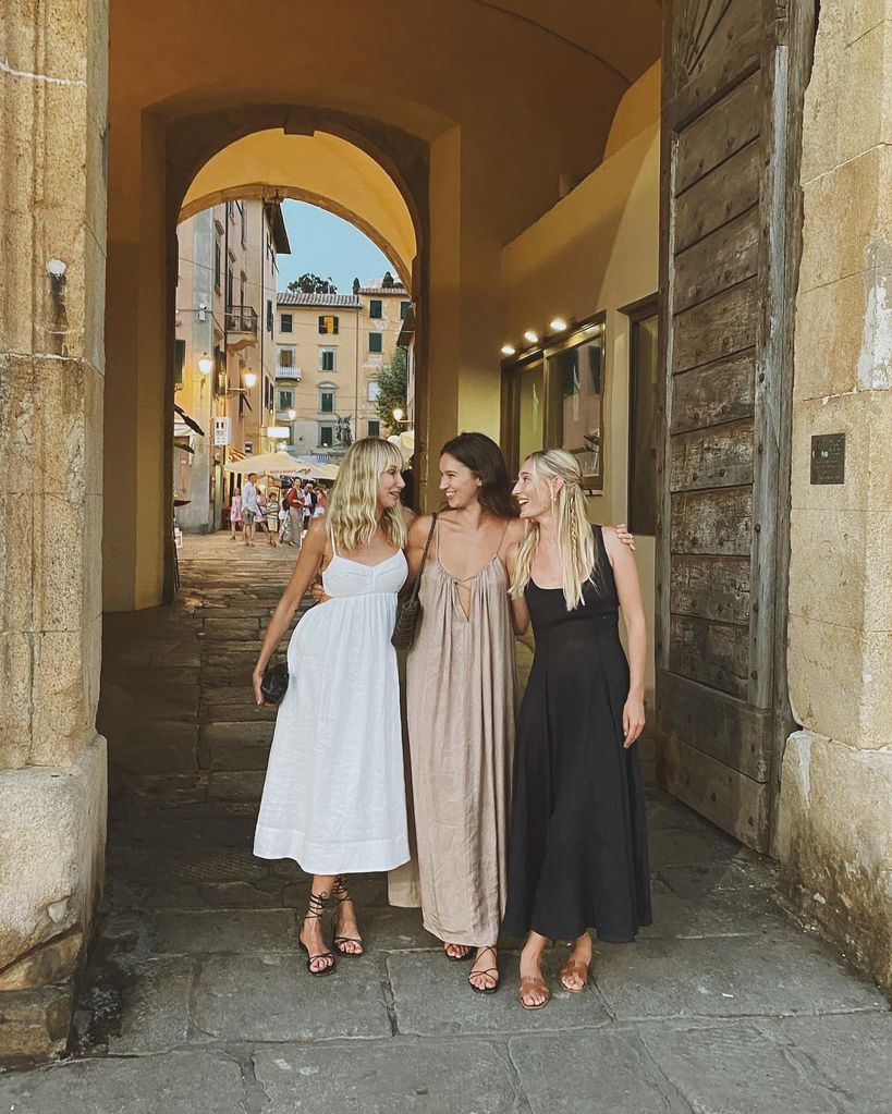 Three women standing in an archway in summer clothes