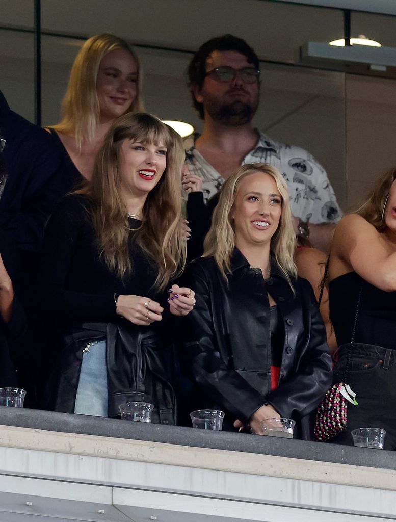 Austin Swift and Sydney Ness are pictured standing behind Taylor Swift 