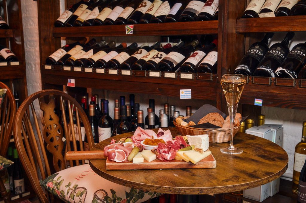 A platter of meats, cheese and a glass of champagne 