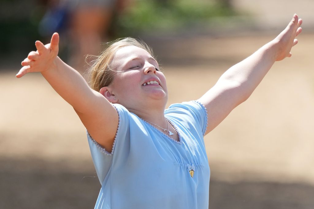 Mia Tindall jumping for joy in a blue top