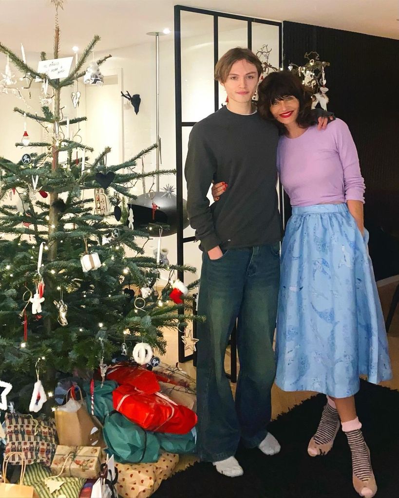 helena christensen and son mingus posing in front of christmas tree