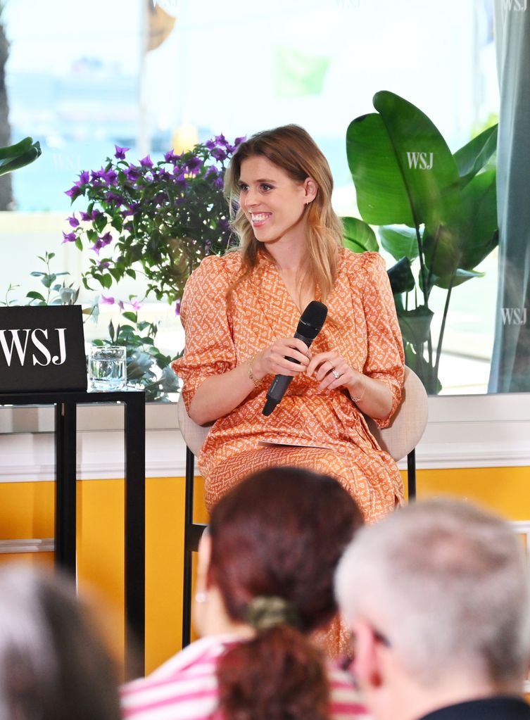 Princess Beatrice smiling and holding microphone
