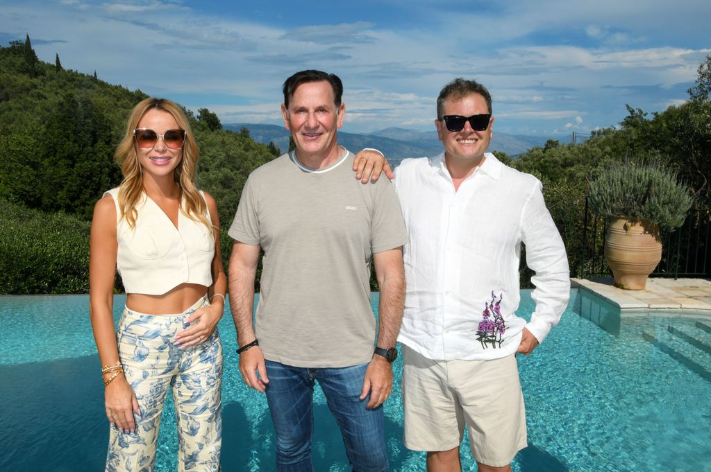 Amanda Holden wearing blue floral trousers and white waistcoat on Amanda & Alan's Greek Job