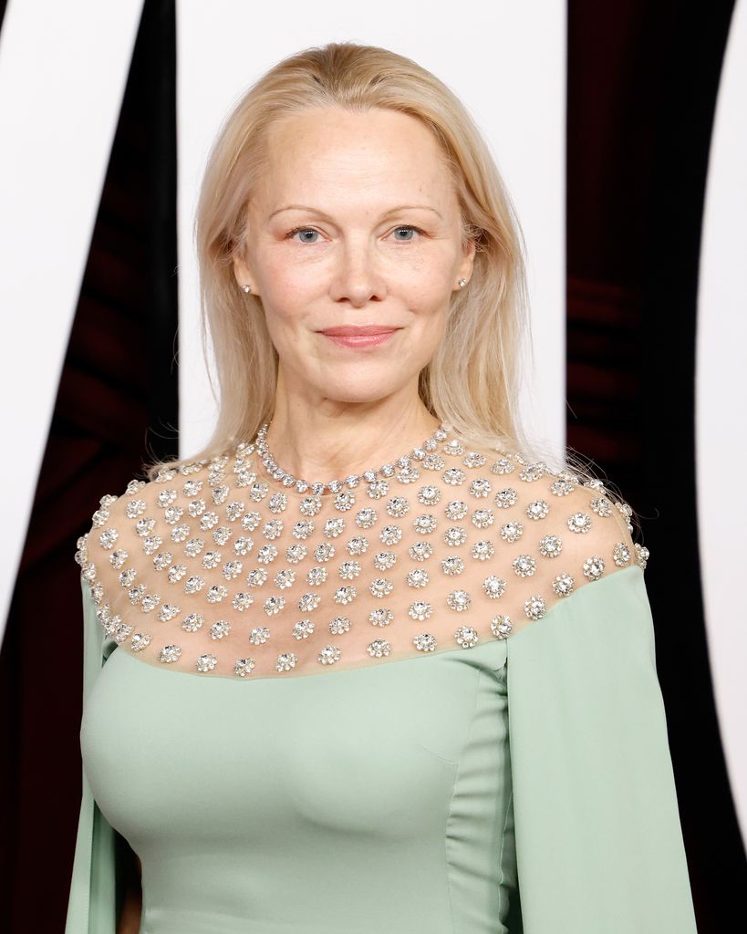 woman smiling on red carpet in mint dress