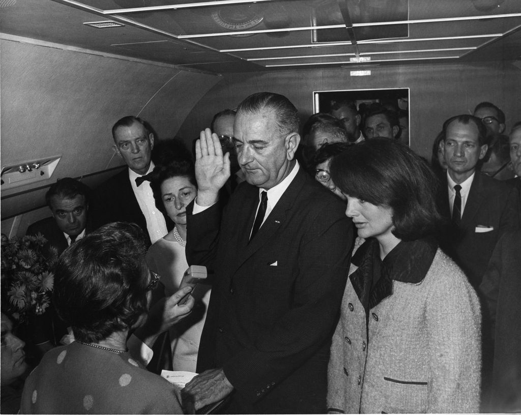 In the aftermath of the assassination of US President John F. Kennedy, American politician and Vice-President Lyndon B. Johnson takes the oath of office to become the 36th President of the United States as he is sworn in by US Federal Judge Sarah T. Hughes on the presidential aircraft, Air Force One, Dallas, Texas, November 22, 1963. Kennedy's widow, Jacqueline Lee Bouvier Kennedy stands beside him at right