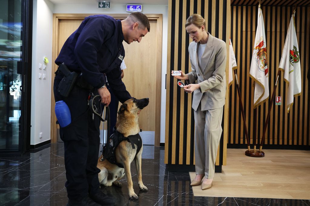 Princess Charlene of Monaco gives a police batch to a dog named Tyson during the presentation ot the canine brigade in The Principality of Monaco on October 27, 2025. The princess is the initiator of the creation of the canine brigade and she is president of SPA Monaco (Societe Protectrice des animaux) (Photo by Valery HACHE / AFP) / / NO TABLOIDS WEB & PRINT, NO DAILY MAIL, NO DAILY MAIL GROUP, NO VOICI, NO CLOSER (Photo by VALERY HACHE/AFP via Getty Images)          