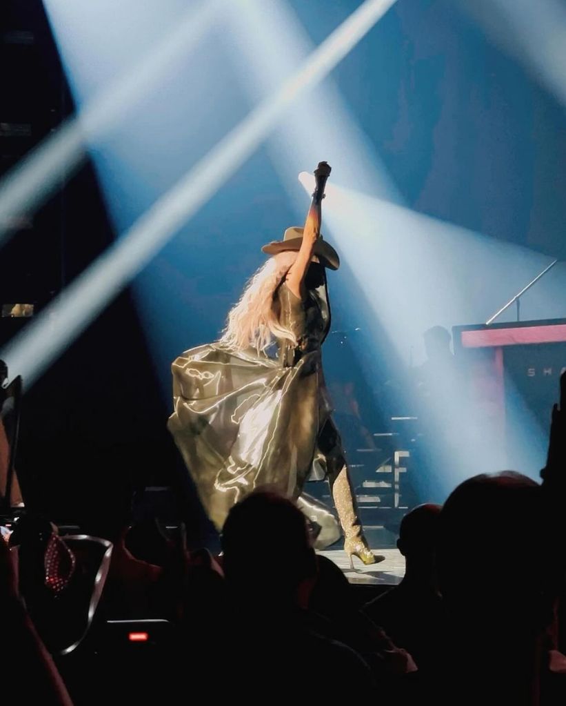Shania Twain on stage in a cape and glittering boots