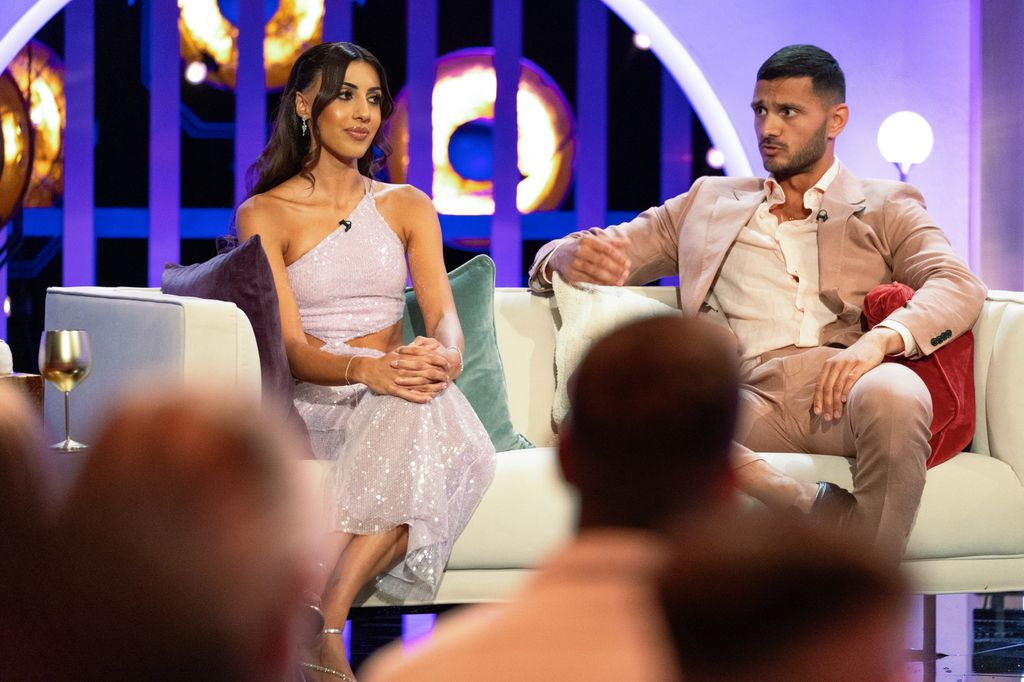 Two people sit on a sofa 