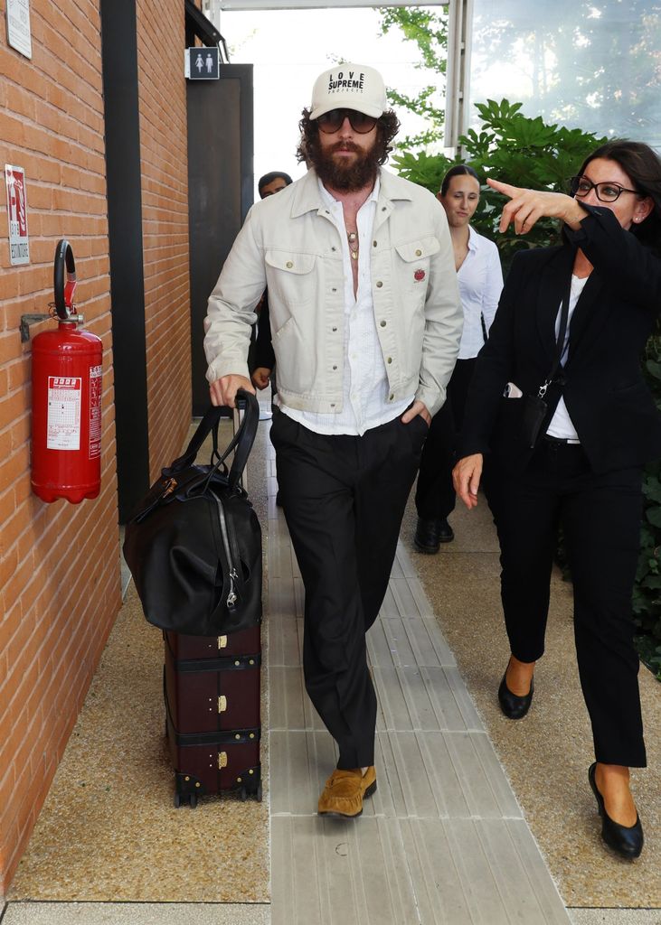 aaron taylor johnson wheeling suitcase with bushy beard and longer hair in venice
