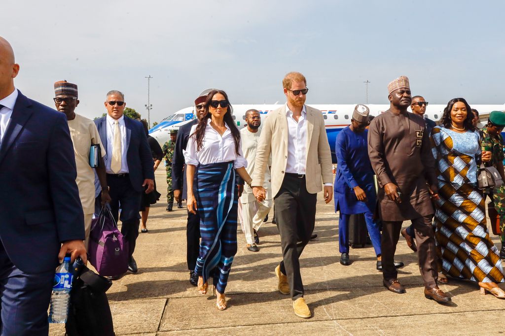 Prince Harry, Duke of Sussex and Meghan walking by plane