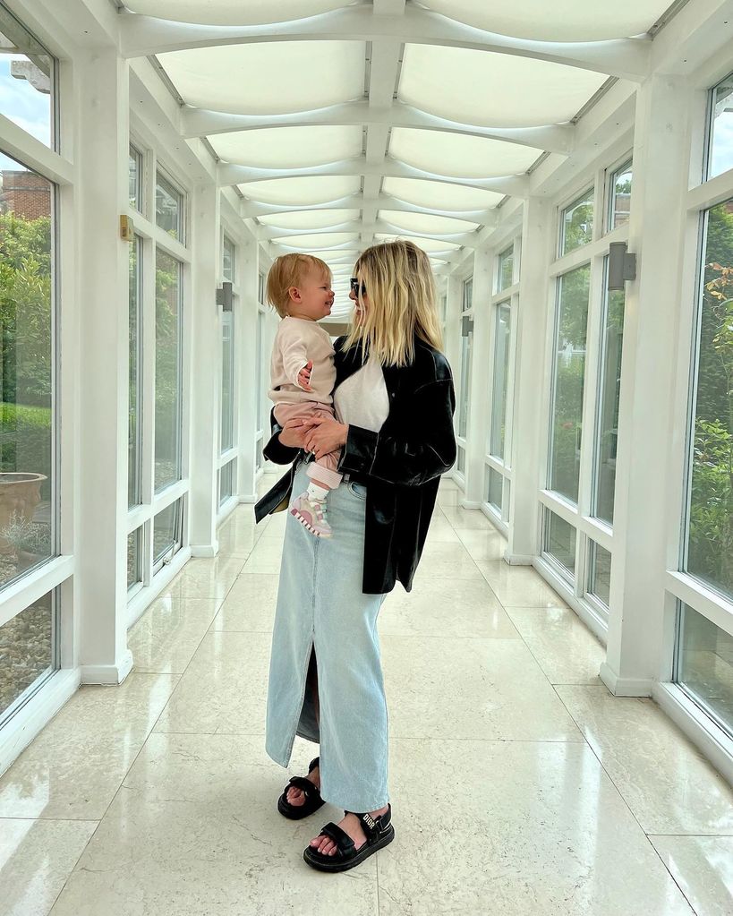 Mollie king holding daughter in conservatory